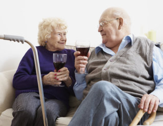 elderly couple holding a glass