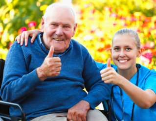 caregiver and elderly woman showing thumbs up