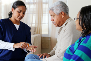 caregiver giving elderly man medicine