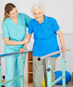 caregiver assisting elderly woman on movement exercise