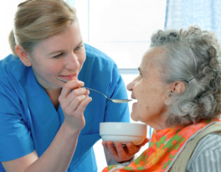senior woman 90 years old being fed by a nurse